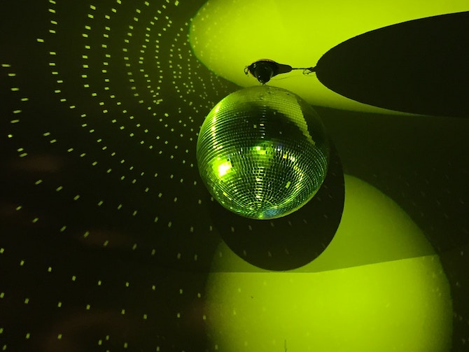 A green-lit room with a disco ball