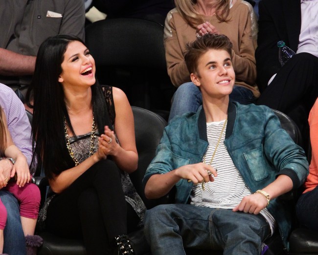 Selena Gomez (L) and Justin Bieber attend a basketball game between the San Antonio Spurs and the Los Angeles Lakers at Staples Center on April 17, 2012 in Los Angeles, California.