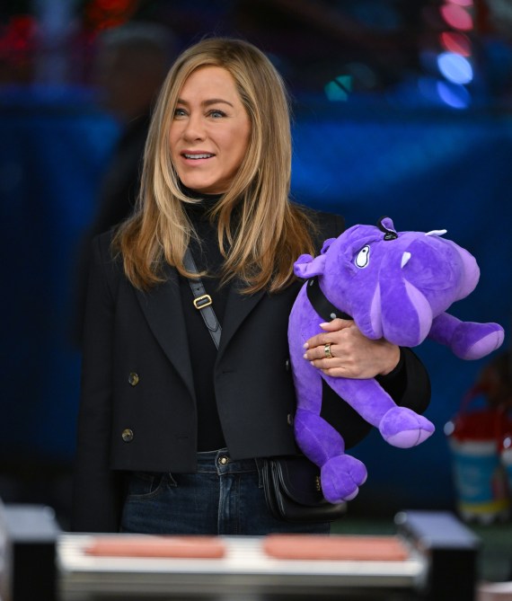 Jennifer Aniston with a mid length layered haircut holding a purple stuffed dog