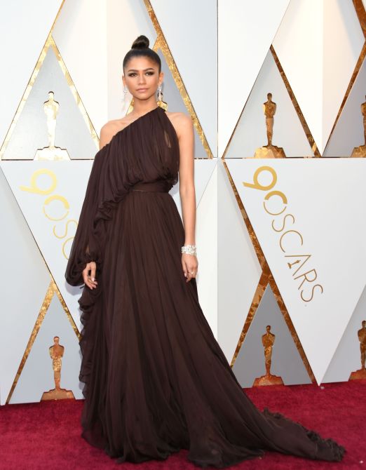 Zendaya in a chocolate brown one shoulder evening gown at the 2018 Oscars red carpet