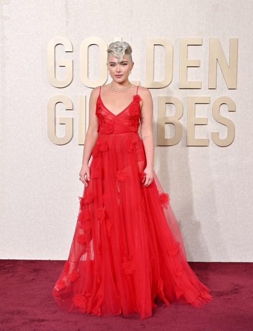Florence Pugh in a red tulle dress adorned with rosettes at the 2024 Golden Globes red carpet
