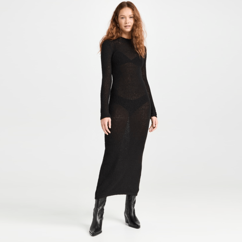 A model wearing a semi-sheer black long-sleeve sweater dress