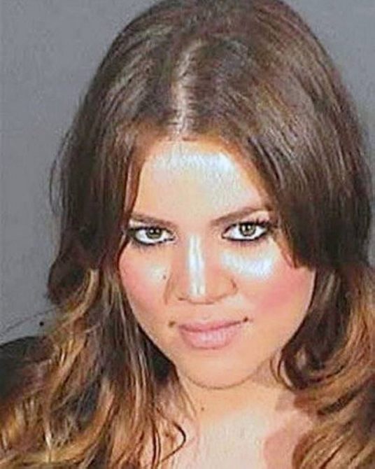 Khloe poses for her mugshot with a grey background