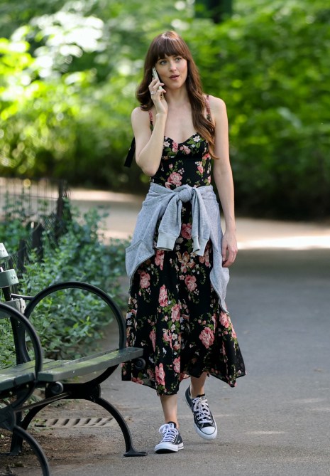 Dakota Johnson wearing a black floral dress with Converse.