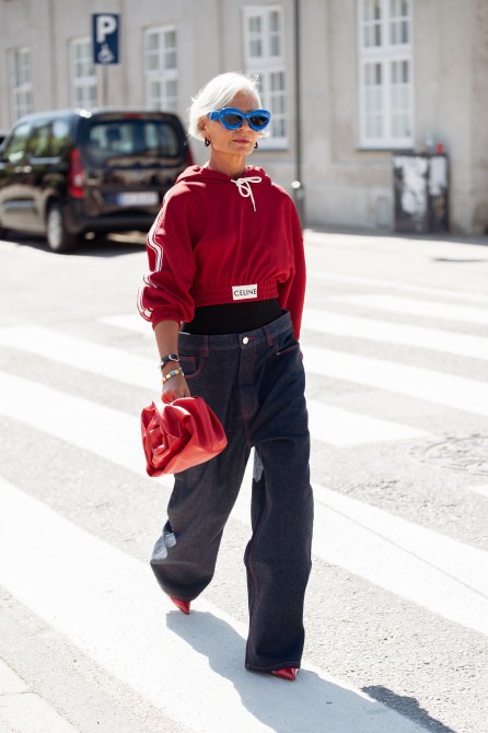 STYLECASTER | Minimalist Outift Ideas, cropped red hoodie, jeans, Celine, Loewe Blue sunglasses