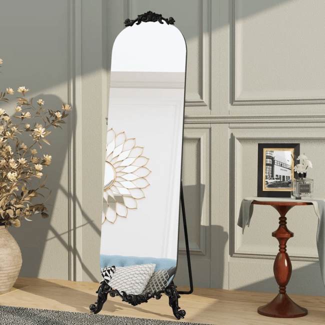 A long, oval-shaped mirror with antique motifs
