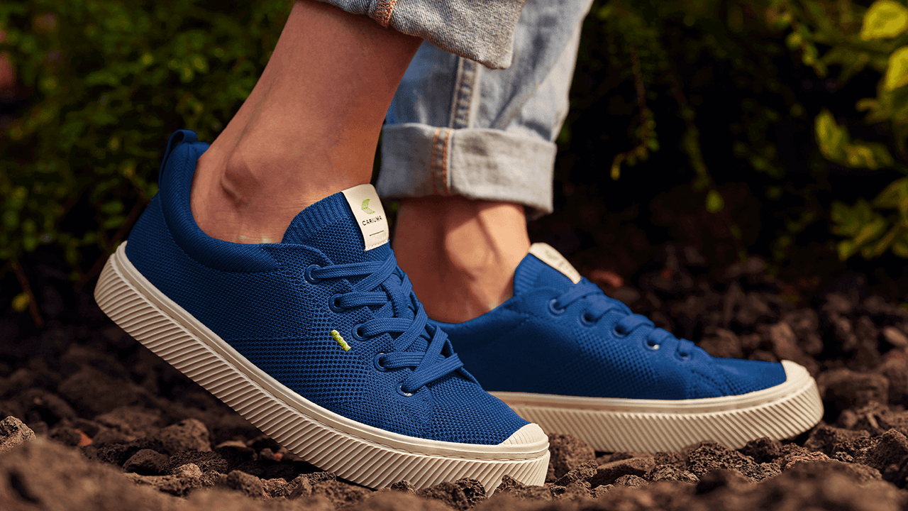 A close up shot of a model wearing the Cariuma Ibi Low Sneaker in blue