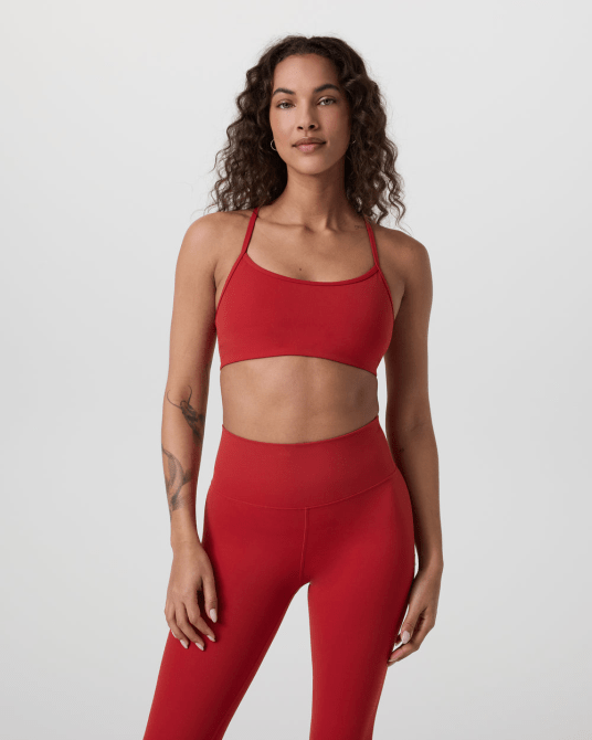 A model wearing the Vuori AllTheFeels Bra in red