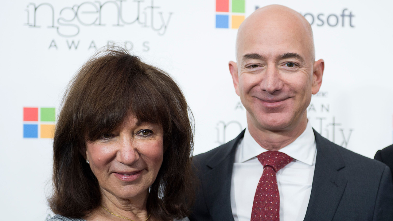 Amazon CEO Jeff Bezos poses on the red carpet with his parents Mike and Jackie, for the Smithsonian Magazine's 2016 American Ingenuity Awards, honoring groundbreaking individuals in several categories, at the National Portrait Gallery on December 8, 2016 in Washington, DC. - Amazon CEO Jeff Bezos received the Technology award for his historic achievement in aviation and space exploration.