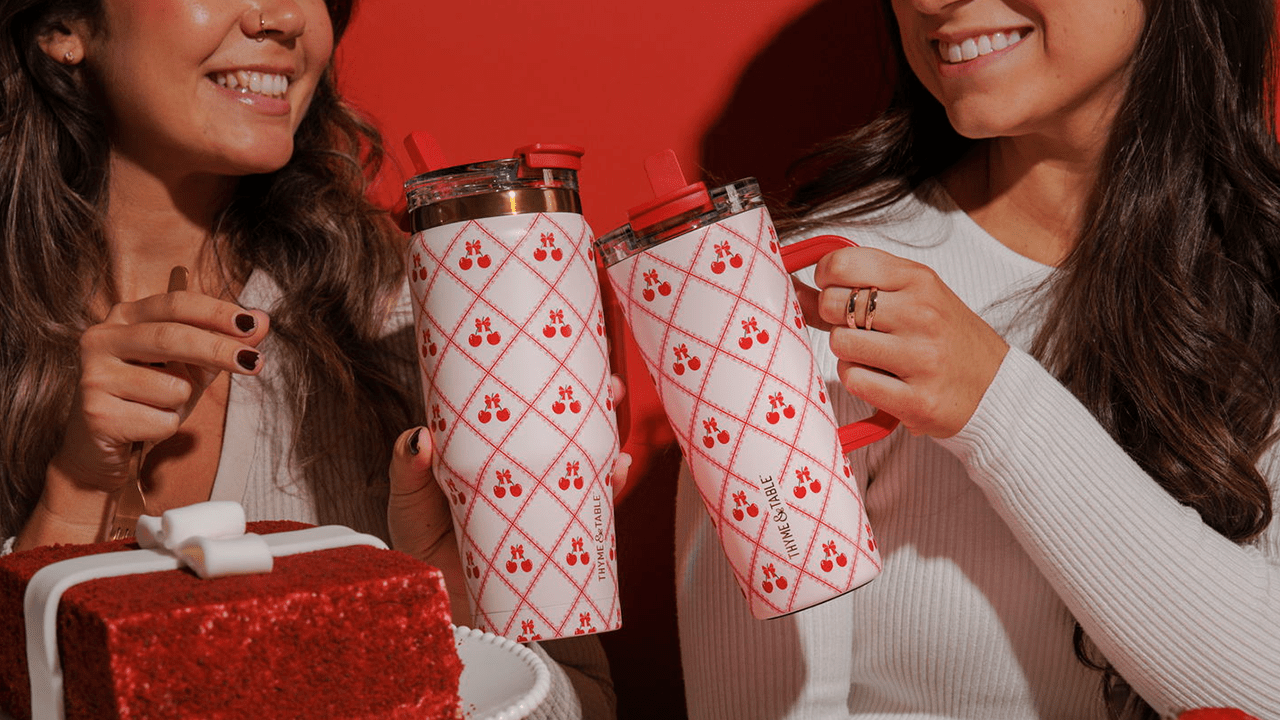 Two women smiling and clinking their Thyme & Table Valentine's Day tumblers together
